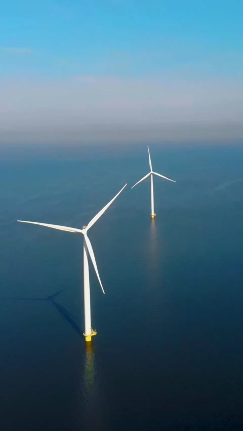 Windmill turbines with a blue sky in the ocean Stock Footage 229256418