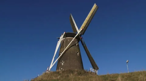 Windmill with turning wicks against blue sky - low angle Stock Footage 34661149