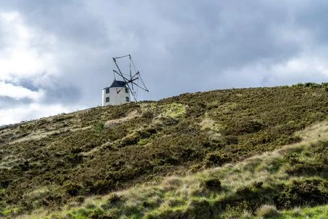 Windmill under wide broken cloud sky Stock Photos