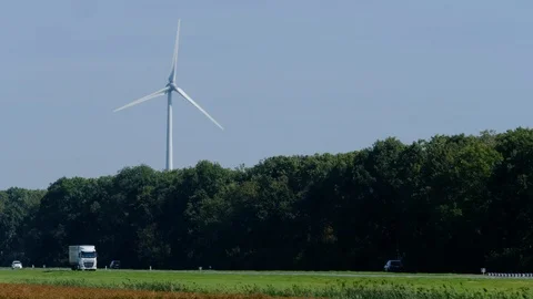 Windmill wind energy turning wicks clean climate green highway trucks and car Stock Footage 95221912