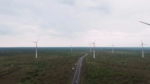 Windmill wind turbine for renewable green energy supply aerial view of car Stock Footage 248408976