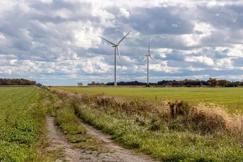 Windmills across farm field Stock Photos