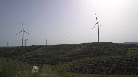 Windmills in action on stepped hills. Panning shot Stock Footage 76988809