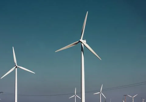 Windmills against a dramatic blue sky. Renewable energy, alternative electricity Stock Photos