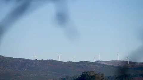 Windmills on a beautiful mountain in the distance. Renewable energy on Stock Footage 168461273