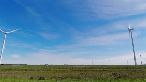 Windmills generating electrical energy on the side of a road. Blue sky with.. Stock Footage 286764372