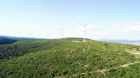 Windmills generating electricity in the forest area accompanied by a sea view Stock Footage 236446584