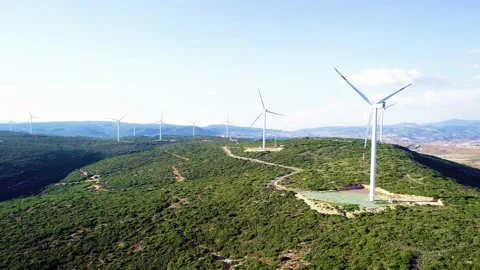 Windmills generating electricity in the forest area accompanied by a sea view Stock Footage 236446695