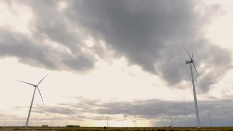 Windmills generating electricity rotating slowly in a field forming part of.. Stock Footage 252326608