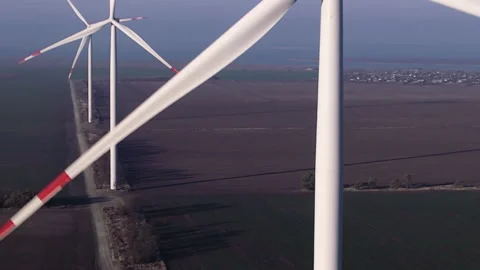 Windmills with large blades generate clean power on field Stock Footage 168477935