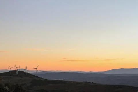 Windmills in the mountains at sunset Stock Photos