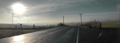 Windmills over road under a bright sun Stock Footage 261626917