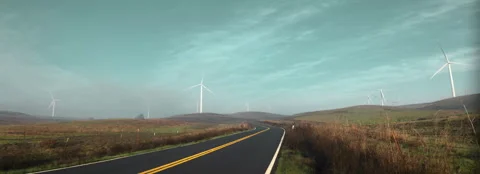 Windmills over winding road Stock Footage 261633782
