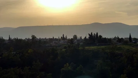 Windmills as a renewable energy source seen on top of hill on sunset Video stock 72268047