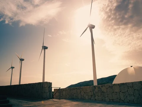 Windmills slowly spinning against dramatic orange blue sky with clouds Stock Footage 72948585