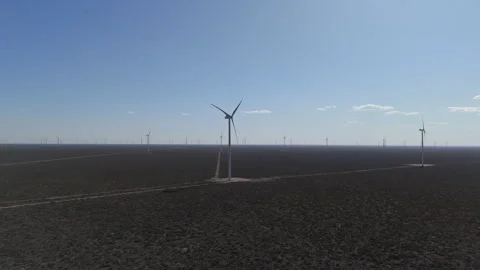 Windmills on a sunny day without clouds, brown fields around, wind park for Stock Footage 293537172
