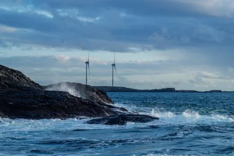 Windmills with waves in foreground Stock Photos