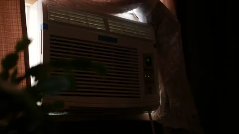 A Window AC Air Conditioning Unit in window - active cooling concept Stock Footage 203471875