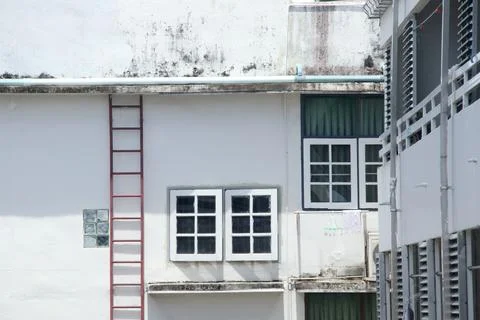 Window and white wall of building with steel ladder. Stock Photos