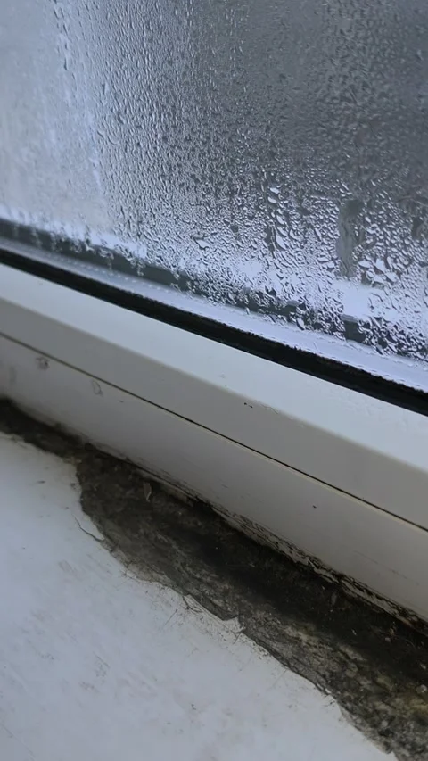 Window in apartment inside is covered with water droplets due to high Vidéo 330491775