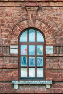 Window with an arch on a brown wall. Stock Photos