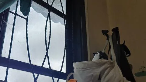 A window with a bag hanging from it Stock Photos