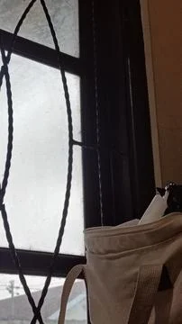 A window with a bag hanging from it Stock Photos