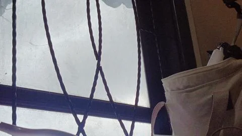 A window with a bag hanging from it Stock Photos