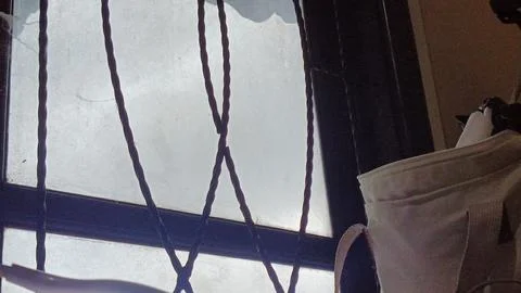 A window with a bag hanging from it Stock Photos