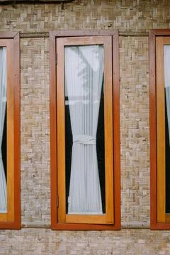 Window with bamboo wall, capturing a serene view of a rustic countryside home Stock-Fotos