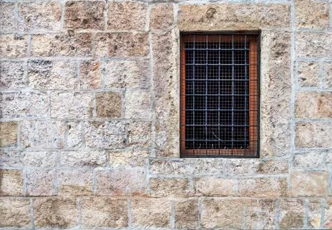 Window with bars in the old stone wall Stock Photos