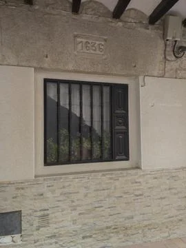 Window with bars in a stone house 写真素材
