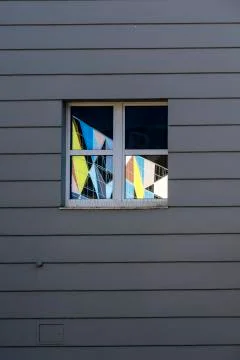 Window on a black house wall with colored mirroring Stock Photos