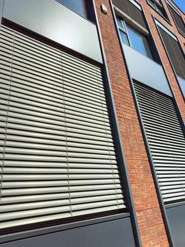 Window blinds on a building in an urban setting during a sunny day Stock Photos