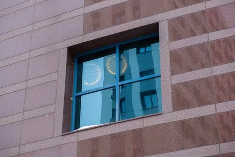 Window with a blue frame on the brown wall of the business center. Stock Photos