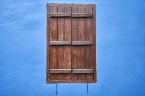 The window with the brown shutter in the blue wall. Cyprus The view of the... Stock Photos