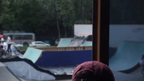 From the window of the building it is seen how girl riding a bike in a skate Stock Footage 104098041