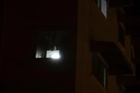 A window in a building is lit up by a light Stock Photos