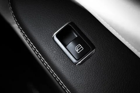 Window button inside luxury car with leather interior. Automatic power contro Photos