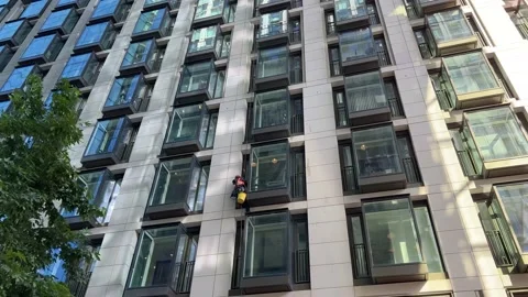 A Window Cleaner abseiling an office block Stock-Footage 162910302