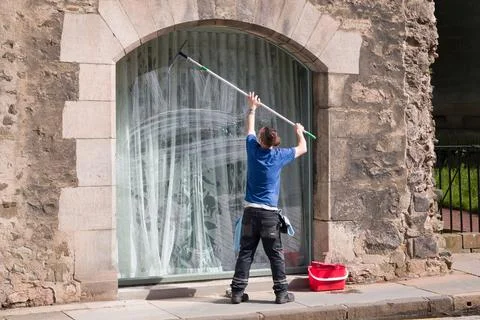 Window cleaner cleaning a window in Edinburgh, UK Stock Photos
