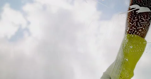 Window cleaner cleaning window with squeegee and wiper on a sunny day Stock Footage 190926783