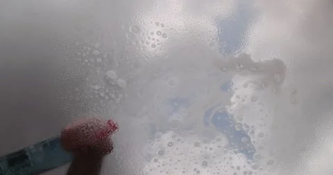 Window cleaner cleaning window with squeegee and wiper on a sunny day Stock-Footage 190937153