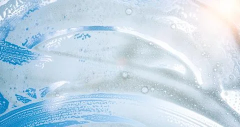 Window cleaner cleaning window with squeegee and wiper on a sunny day Stock Photos