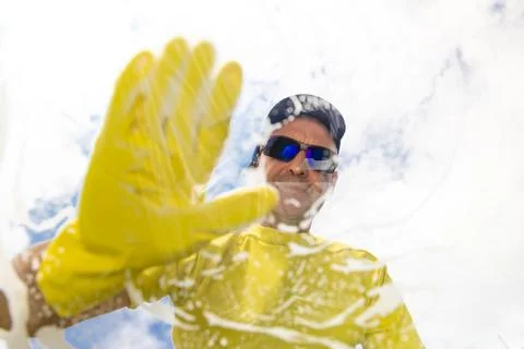 Window cleaner cleaning window with squeegee and wipe Stock Photos