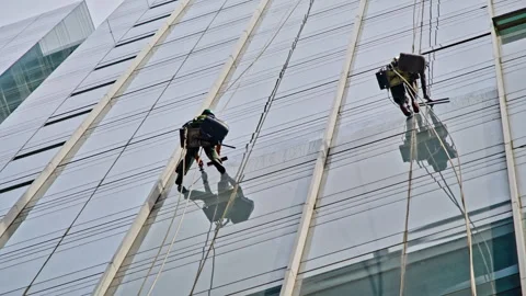 Window Cleaner Rappelling on Slanted Glass Roof Structure Stock Footage 340241772