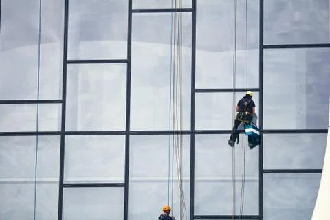 Window cleaners at work. Window cleaner, in the suspension system. Industrial Stock Photos