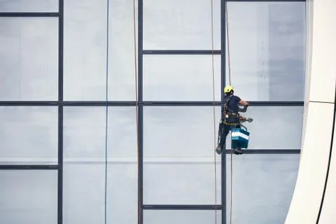 Window cleaners at work. Window cleaner, in the suspension system. Industrial Stock Photos