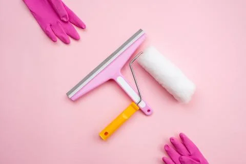 Window cleaning brush and roller for repair and rubber gloves on a pink backg Stock Photos