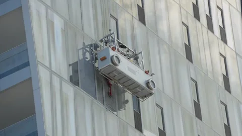 Window cleaning cradle ascending skyscraper facade in Tel Aviv Stock-Footage 345653484